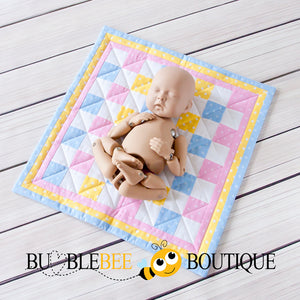 StandInBaby shows the size of the Baby Dots pink, blue & yellow mini patchwork quilt
