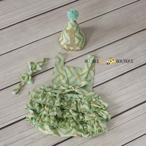 Back view of Mist Green & Gold Glimmer Chevron Girls' Cake Smash Outfit. Frilly romper, headband, party hat.