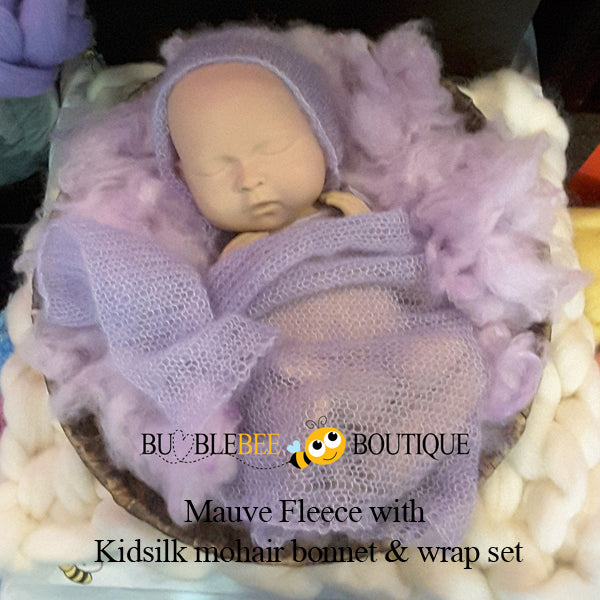 SIB resting on mauve fleece with kidsilk mohair bonnet & wrap set